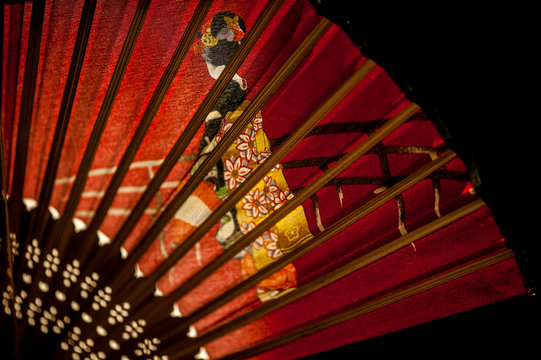 Red fan decorated with japanese woman on a bridge, Kyoto, Japan