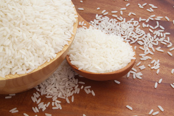 Rice in bowl and wooden spoon on table 