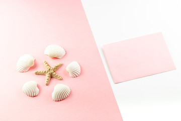Flat lay top view Pink envelope, seashells on a pink background. Summer tropical vacation background. 
