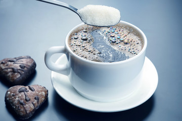 white cup with black coffee and spoon with sugar