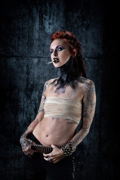 Young tattooed woman, one-eyed, a cigarette in her hand