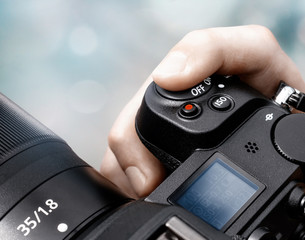 Finger pushing shutter button on a camera close-up