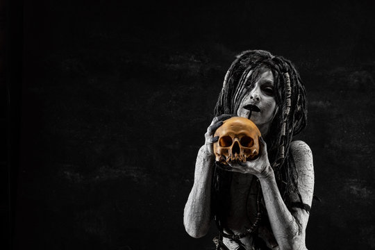 Portrait of a shaman holding a human skull in his hands