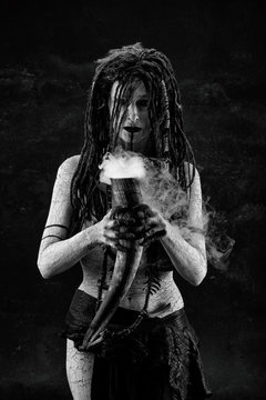 Portrait of a shaman holding a steaming horn