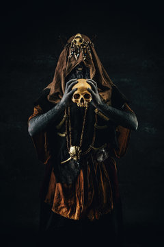 Portrait of a shaman holding a human skull