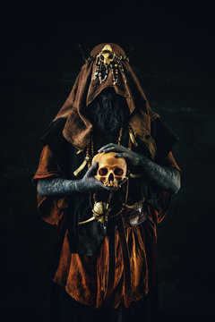 Portrait of a shaman holding a human skull