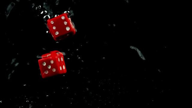 Rolling two red dice splashing in water
