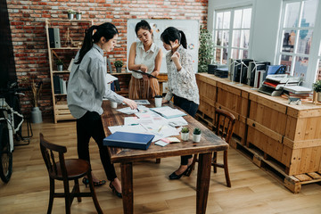 full length of business colleagues meeting in modern room with city view through window. three busy...