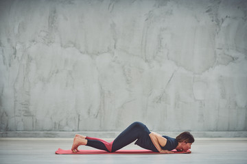 Fit sporty Caucasian bruntte lying in Eight Pointyoga pose.