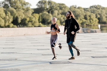 Obraz premium Young couple man woman in Jogging outdoor run for each other