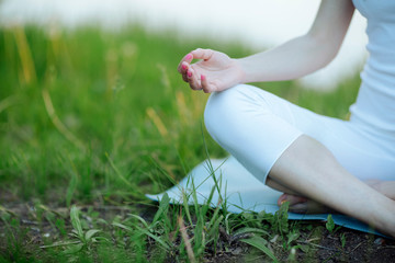 Woman doing meditation yoga mudra with hands  on  knees and relax at blooming  lush meadow with...