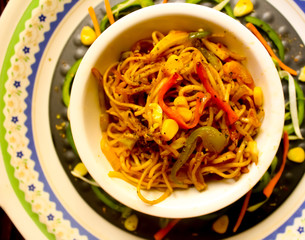 Veg noodles in a bowl topped with capsicum,sweet corn,baby corn 