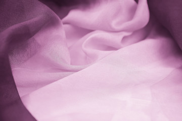 The texture of the satin fabric of lilac color for the background