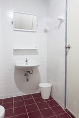 Fototapeta na wymiar Mirror in white toilet room with red floor textile