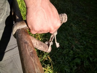 the farmer mows the grass with a manual scythe