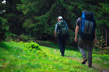 Fototapeta na wymiar Two friends travel in the mountains with backpacks
