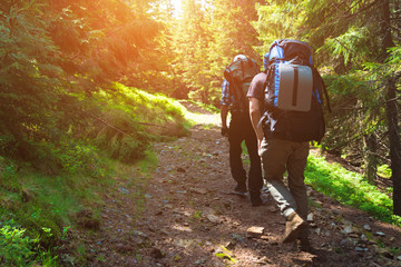 Two friends travel in the mountains with backpacks