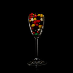 Creative candy set in a wine glass on black background