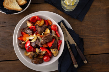 Plate fried beef meat, new potatoes and vegetables top view