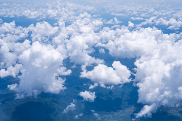 Sky scape cloudscape from aerial airplane shot of blue clouds. View flying above moutain from windows over Loei, Thailand.