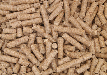Natural wooden pellets background or pattern. Cheap energy and cats litter.