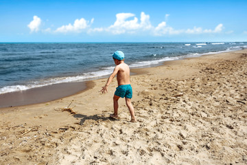 Young boy on beach and summer landscape of sea. Free space for your decoration. 