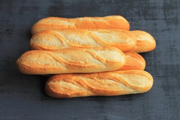 French baguettes on black wooden background, fresh bread.