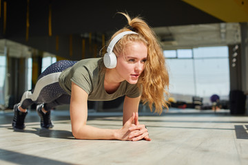 Girl in sports wear does warmnig up before the training.