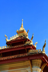 Golden naga on Art Roof of Buddhist temple with blue sky in Wat Pha That Luang Temple Vientiane Province, LAOS