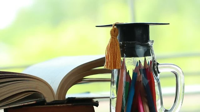 Education knowledge learning study abroad international Ideas. Graduation hat on glass bottle pencils with old open textbook stack piles of literature. Alternative studying in success, Back to School