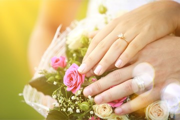 People hands with rings and flowers on background, wedding concept,close up