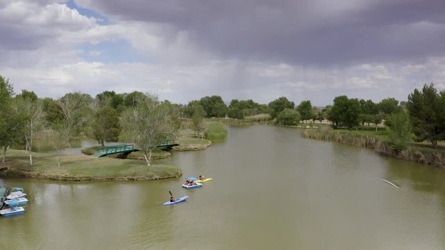 Aerial View of People in Kayaks and Paddleboat on Green Park Lake