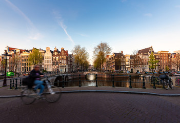 Amsterdam people riding bicycles in historical part in Amsterdam, Netherlands.