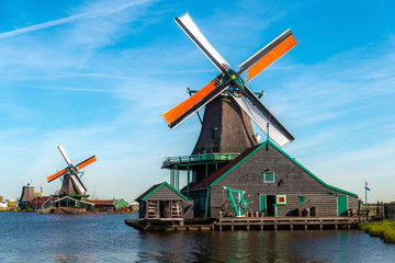 Traditional dutch windmills located by the river Zaan, in Zaanse Schans, Netherlands.