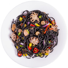 black spaghetti with seafood and vegetables on a white plate of isolate
