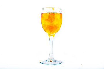 Orange food coloring diffuse in water inside wine glass with empty copyspace area for slogan or advertising text message, over isolated white background.