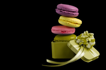 Macaroons box top view. Sweet french macaroons cake on the yellow background.