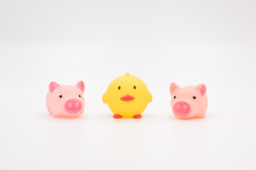 Yellow chick and three pink pig cartoon animal toys neatly arranged on a white background