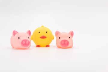 Yellow chick and 2 pink pig cartoon animal toys neatly arranged on a white background