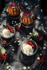 Fresh red currants and rum baba with cream and chocolate in the country