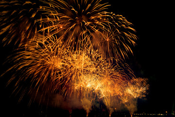 Beautiful colorful fireworks display on the urban lake for celebration on dark night background. colorful fireworks at night.