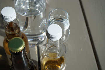 Caps on glas bottles filled with cider with some clear glasses in the background