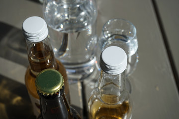 Caps on glas bottles filled with cider with some clear glasses in the background