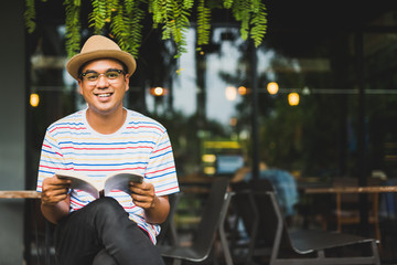 Young asian man reading book.