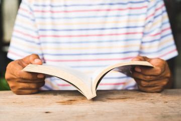 Young asian man reading book.