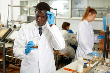 Focused lab technician checking for result of  experiment in laboratory
