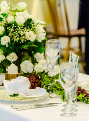 Luxury party dinner table setting with tableware and silverware and glasses set and Candlestick and flower in restaurant.