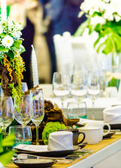 Luxury party dinner table setting with tableware and silverware and glasses set and Candlestick and flower in restaurant.