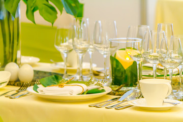 Luxury party dinner table setting with tableware and silverware and glasses set and Candlestick and flower in restaurant.