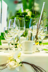 Luxury party dinner table setting with tableware and silverware and glasses set and Candlestick and flower in restaurant.